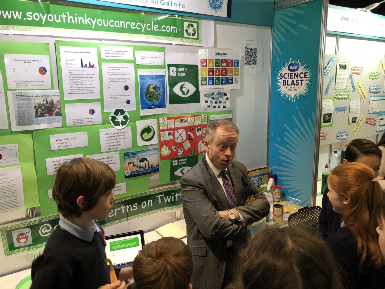 Minister Ciaran Cannon learns about the So You Think You Can Recycle Project from students in Clontuskert NS at ESB Science Blast in the RDS